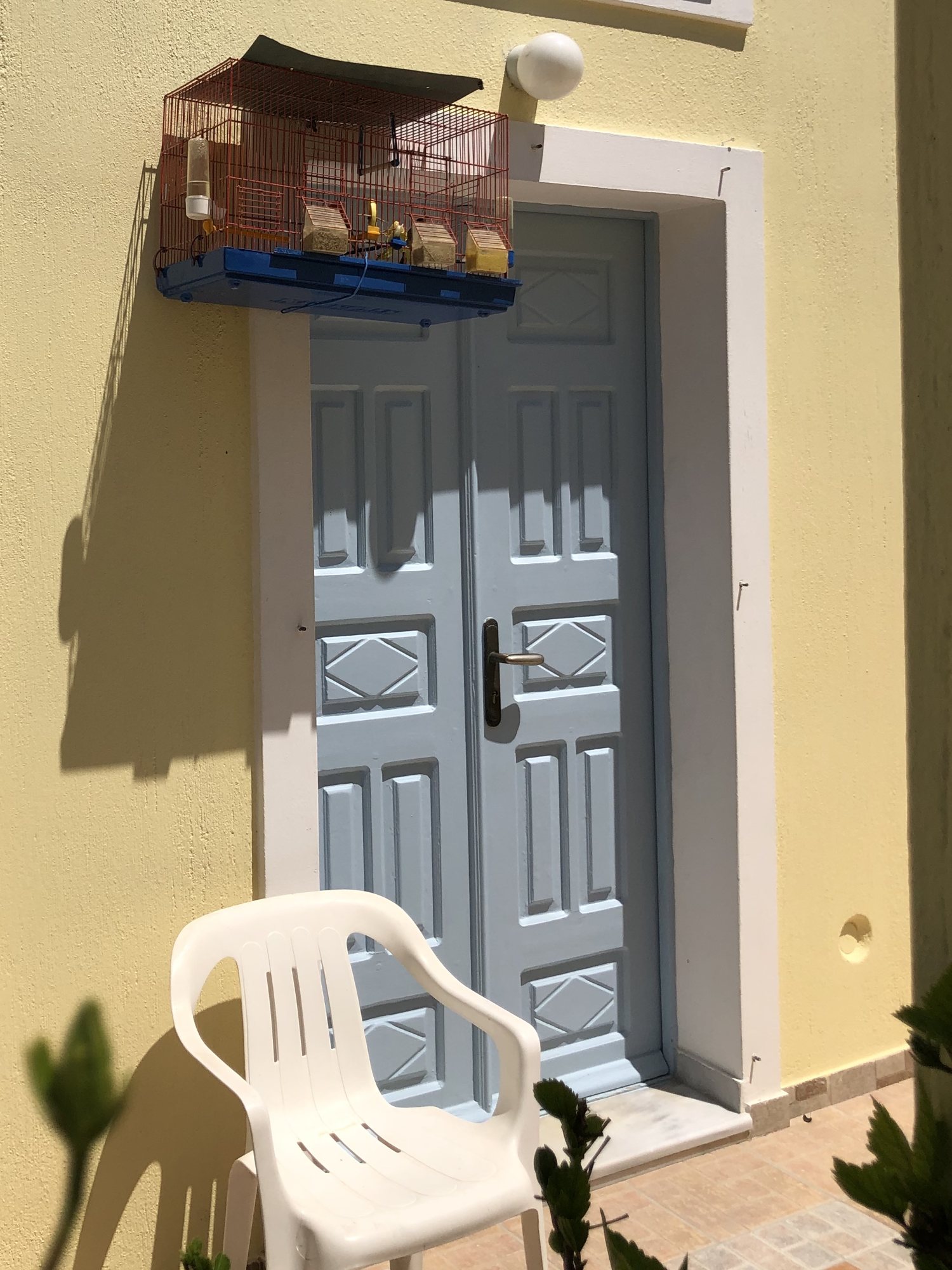 Pet birds kept in cages outside a door in Santorini. This was common in both Crete and Santorini.