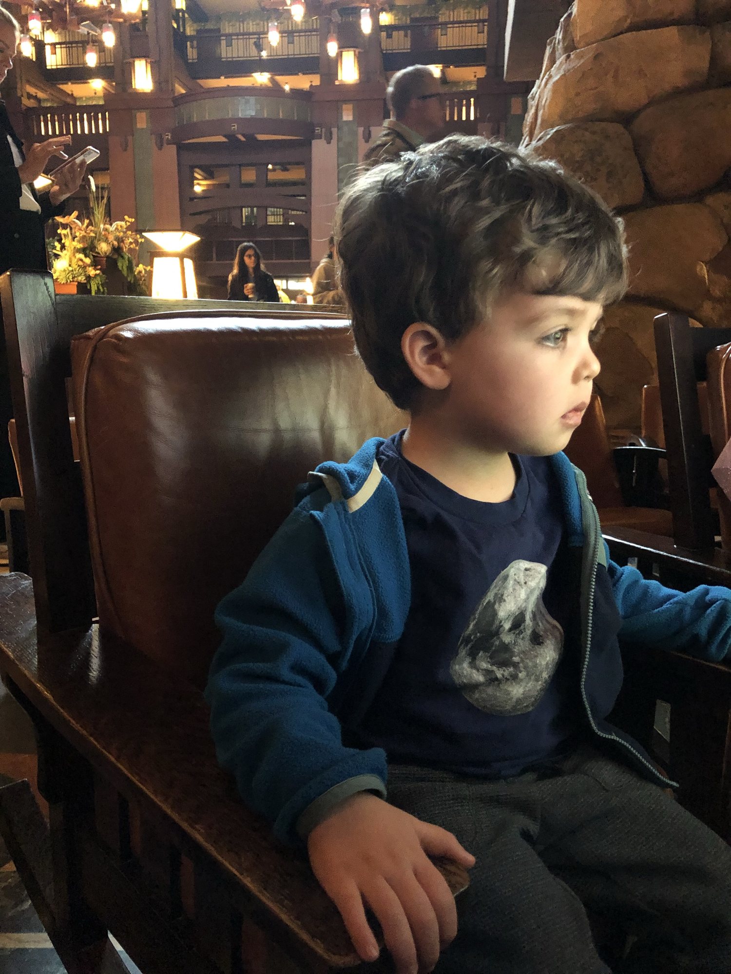 He loves the cartoons in the hotel lobby. We love how distinguished he looks in the little leather rocking chairs - adorbs :)